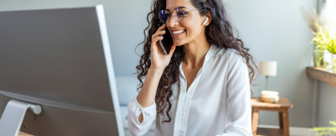 A smiling professional at her desk takes a phone call that was answered right away